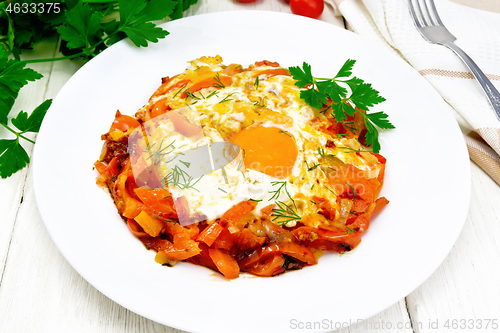 Image of Scrambled eggs with vegetables in plate on board