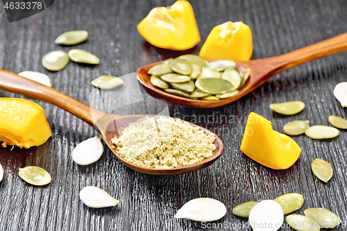 Image of Flour and seeds pumpkin in spoons on dark board