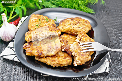 Image of Fritters meat in black plate on wooden board