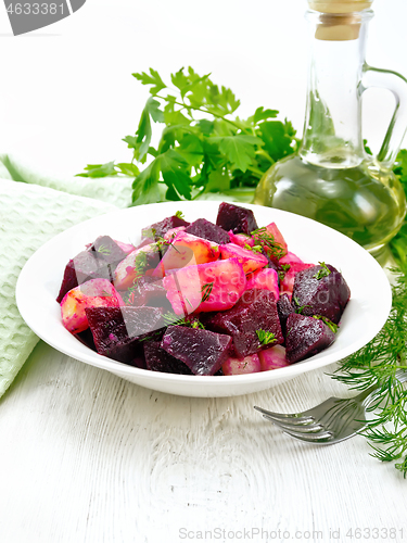 Image of Salad of beets and potatoes in plate on board