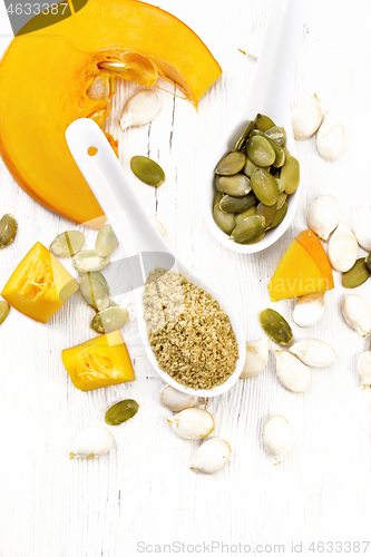 Image of Flour and seeds pumpkin in spoons on light board top