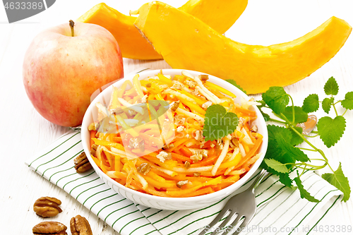 Image of Salad of pumpkin and apple in bowl on board