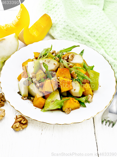 Image of Salad of pumpkin and pear in plate on light wooden board