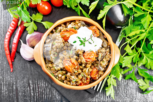 Image of Lentils with eggplant and tomatoes in bowl on black board top