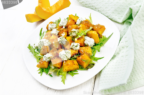 Image of Salad of pumpkin and cheese in plate on light board