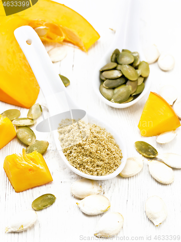 Image of Flour and seeds pumpkin in spoons on light wooden board