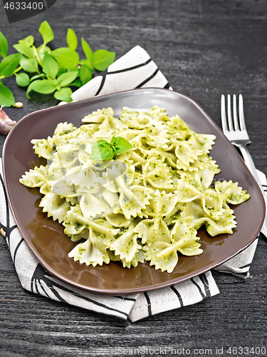 Image of Farfalle with pesto in plate on black board