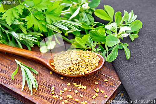 Image of Fenugreek in spoon with herbs on black board