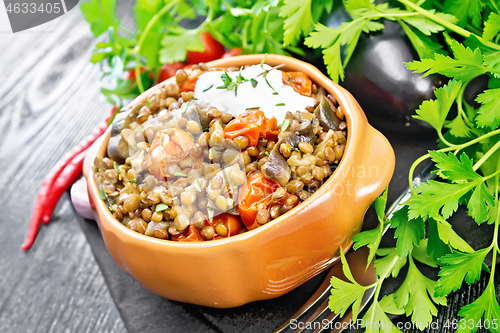 Image of Lentils with eggplant and tomatoes in bowl on black board
