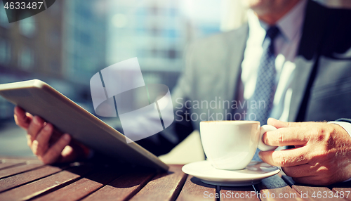 Image of senior businessman with tablet pc and coffee