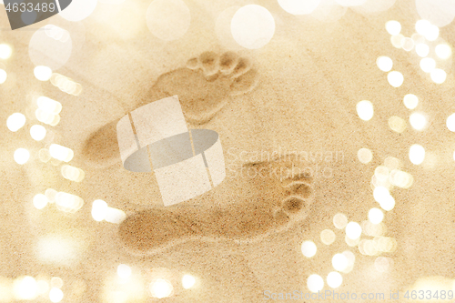 Image of footprints in sand on summer beach