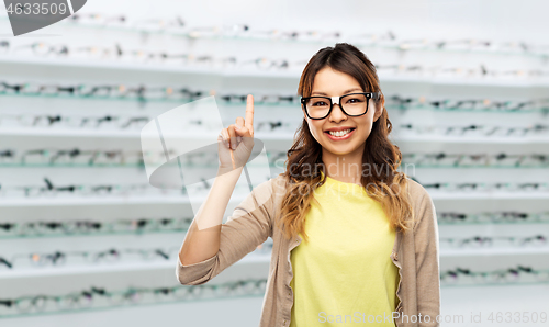 Image of woman in glasses with finger up over optics store