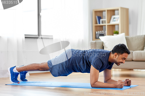 Image of man doing plank exercise at home