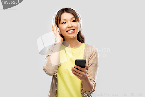 Image of asian woman in headphones listening to music