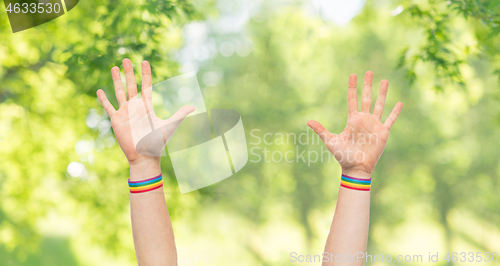 Image of hands with gay pride rainbow wristbands