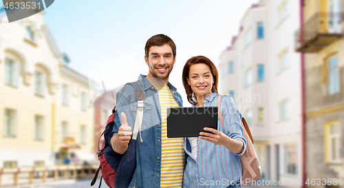 Image of couple of tourists with tablet computer in city