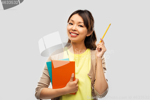 Image of asian student woman with books and pencil