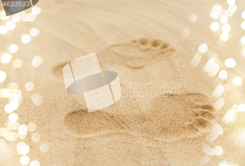 Image of footprints in sand on summer beach