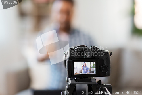 Image of camera recording video blogger showing thumbs up