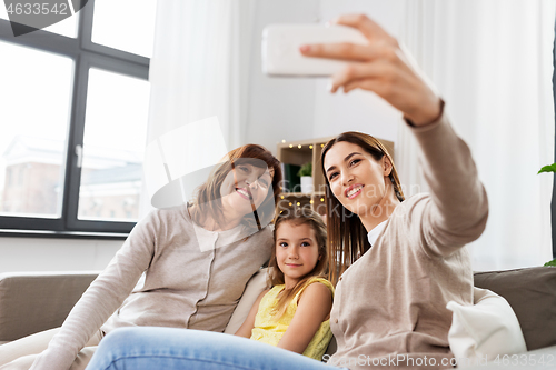 Image of mother, daughter and grandmother taking selfie