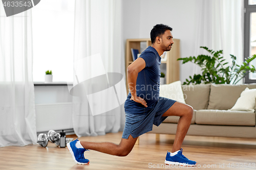 Image of indian man exercising and doing lunge at home