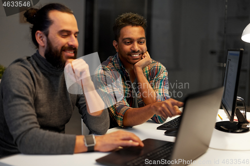 Image of creative team with computer working late at office