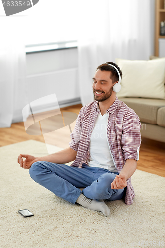 Image of man in headphones meditating listening to music