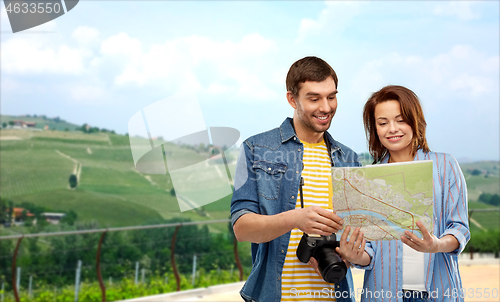 Image of happy couple of tourists with map and camera