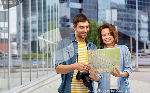 Image of couple of tourists with map and camera in city