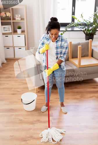 Image of african woman or housewife cleaning floor at home