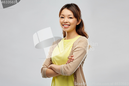 Image of happy asian woman over grey background