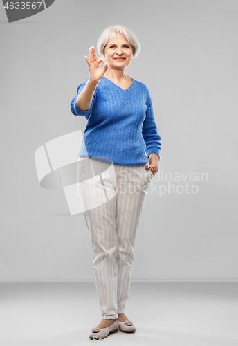 Image of portrait of smiling senior woman making ok gesture