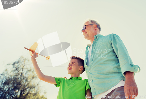 Image of senior man and boy with toy airplane over sky