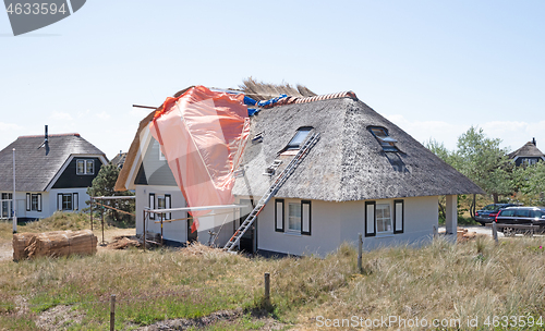 Image of Thatched roof with straw and tools