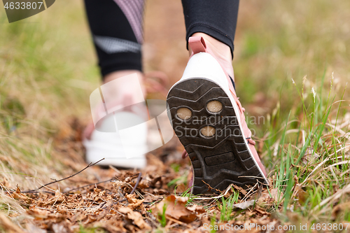 Image of Rear close up view of female step on nature track. Young woman hiking in nature. Adventure, sport and exercise concept