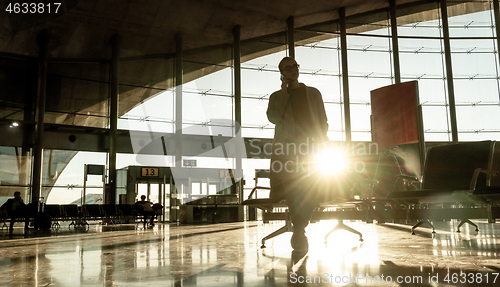 Image of Silhouette of woman stucked at airport terminal over flight cancellation,calling family, sitting in almost empty airport terminal due to coronavirus pandemic, Covid 19, outbreak travel restrictions