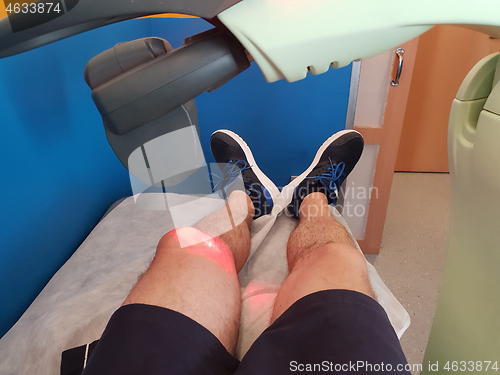 Image of Physical therapy using a laser to treat an injured knee