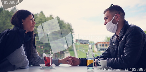 Image of couple in restaurant wearing corona virus  medical protective fa