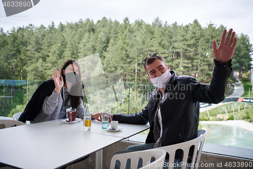 Image of couple in restaurant wearing corona virus  medical protective fa