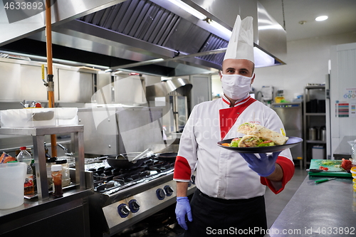 Image of chef cook wearing face protective medical mask for protection fr