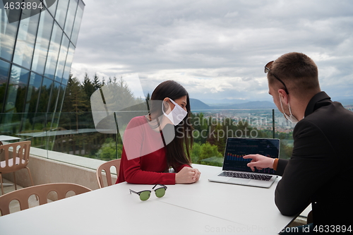 Image of business people wearing protective mask