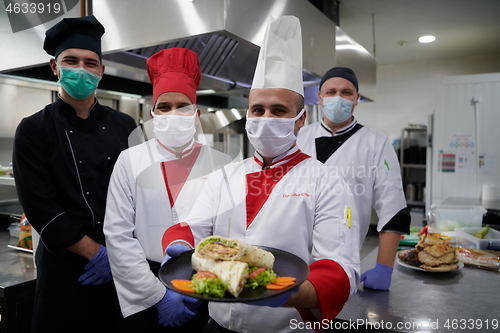 Image of group chefs standing together in the kitchen at restaurant weari