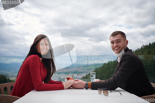 Image of couple with protective medical mask  having coffee break in a re