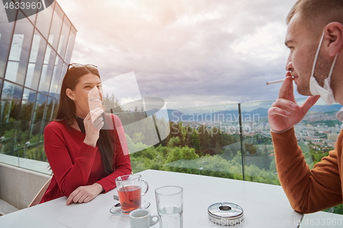 Image of couple in restaurant wearing corona virus  medical protective fa