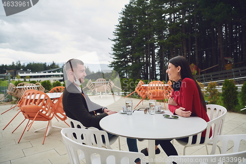 Image of couple with protective medical mask  having coffee break in a re