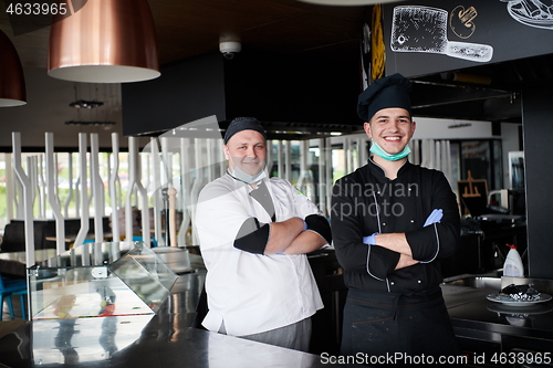 Image of group chefs standing together in the kitchen at restaurant weari