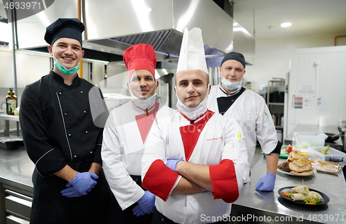 Image of group chefs standing together in the kitchen at restaurant weari