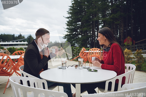 Image of couple with protective medical mask  having coffee break in a re