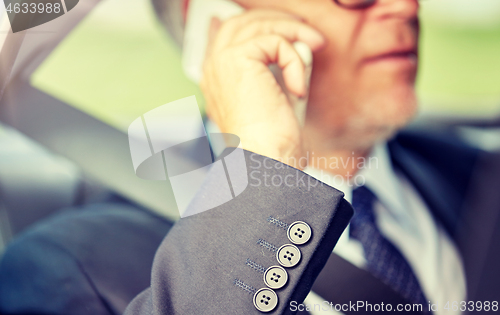 Image of senior businessman calling on smartphone in car