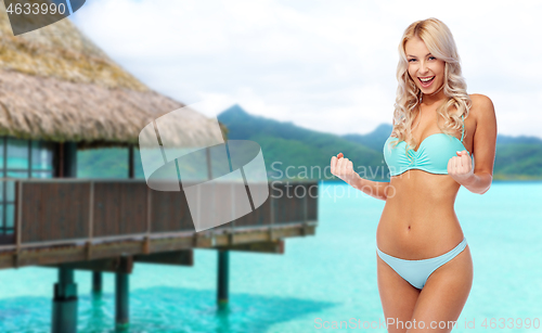 Image of happy young woman in bikini doing fist pump